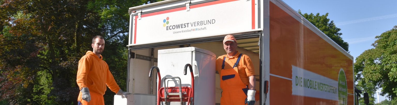 vier verschieden farbige Mülltonnen vor einem Zaun