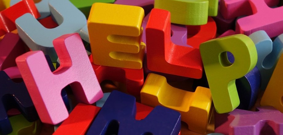 Bunter Buchstabensalat, die das Wort Help ergibt.