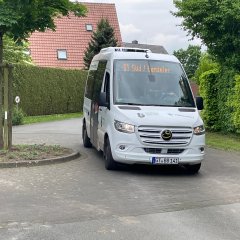 Dorfbus während der Fahrt, wie er um die Ecke fährt.