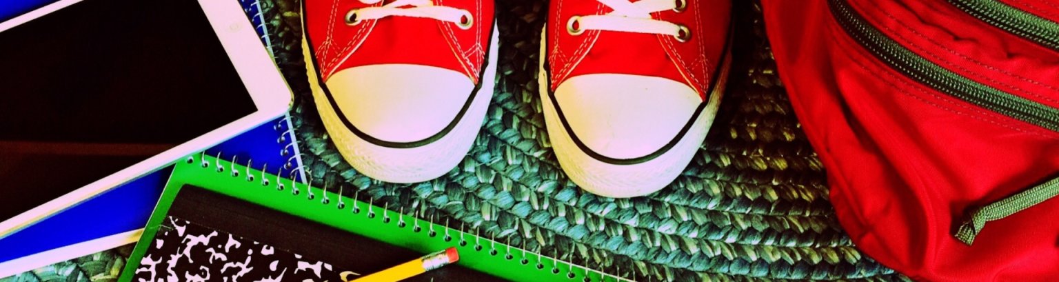 Rote Turnschuhe mit bunten Schulsachen