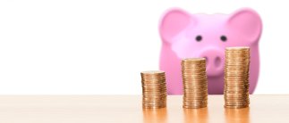 Sparschwein mit Münzen im Vordergrund 